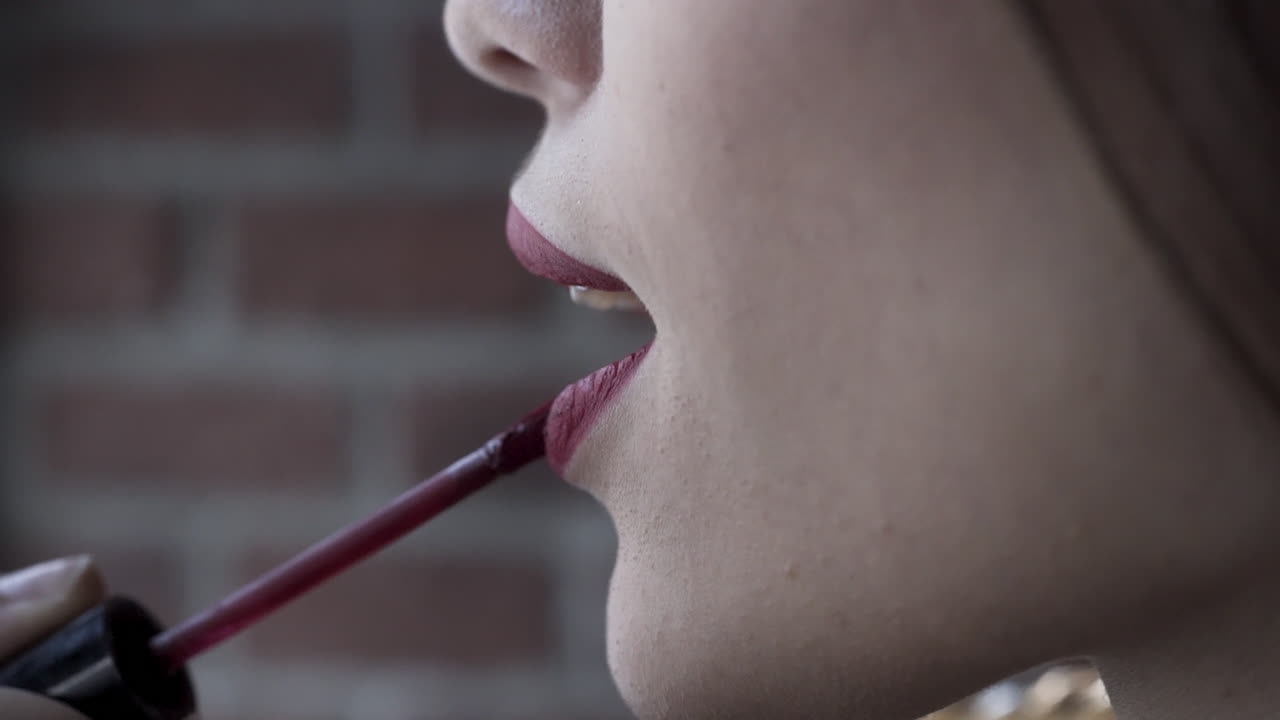 mujer aplicando lápiz labial