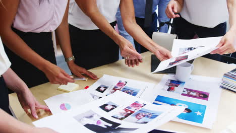 Mid-section-of-colleagues-brainstorming-at-a-table,-close-up