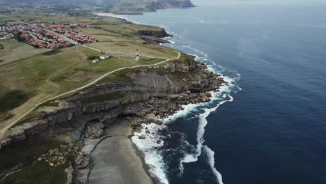 Faro-De-Ajo-Sobre-Acantilados-Con-La-Ciudad-Al-Fondo,-Cantabria.