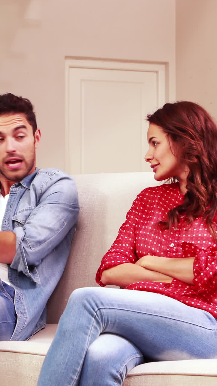 una joven pareja discutiendo en la sala de estar.