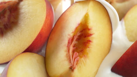 peaches poured with yogurt - a milky liquid covers the fruit in slow motion