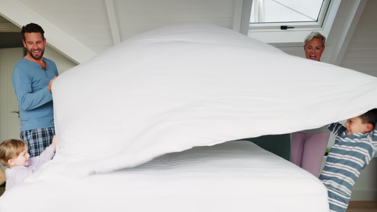 feliz mañana y una familia haciendo la cama