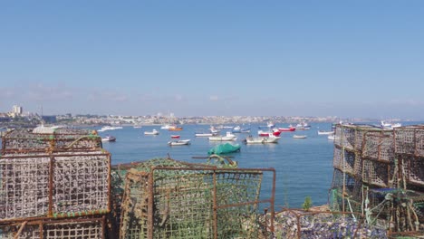 toma panorámica de jaulas de pesca tradicionales y barcos amarrados en el fondo por el puerto deportivo de cascais, portugal