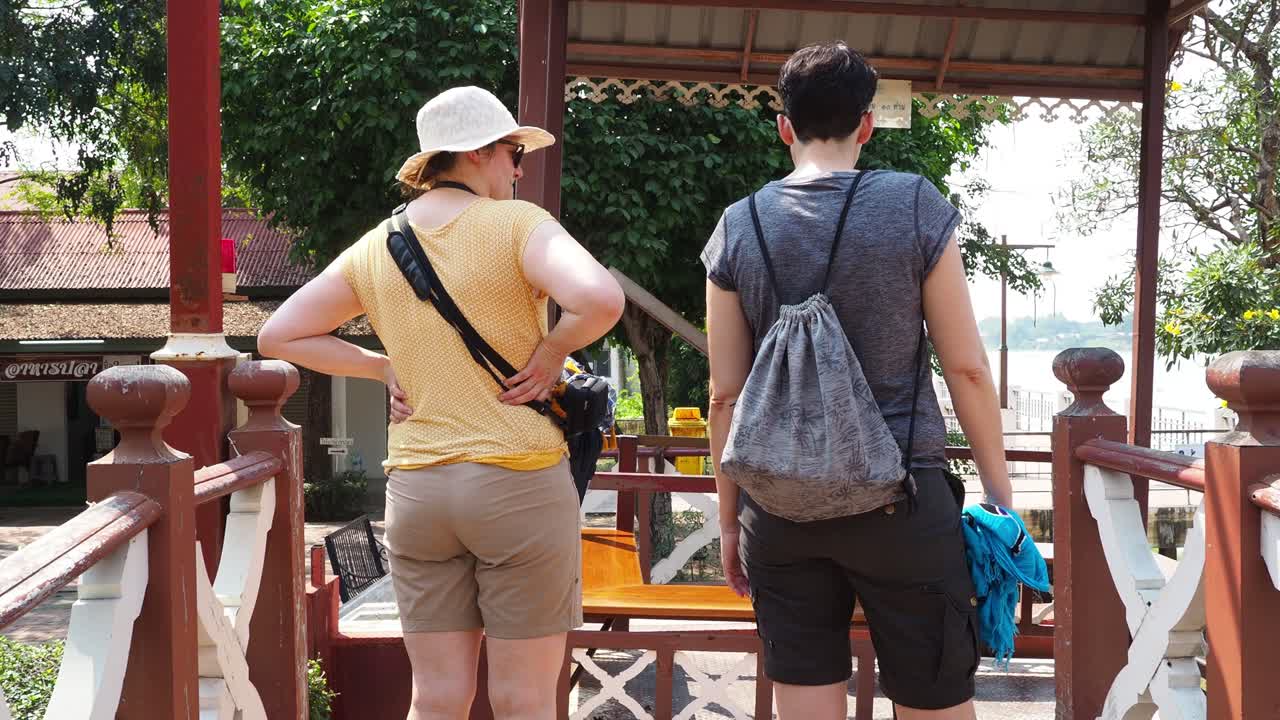 Two tourists walking towards a cable car.