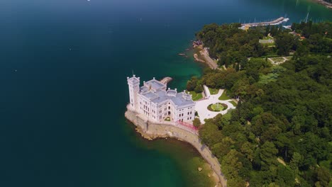 A-Través-De-La-Lente-De-La-Cámara-De-Un-Dron,-Se-Puede-Contemplar-La-Sorprendente-Belleza-Del-Castillo-De-Miramare,-Orgullosamente-Ubicado-Frente-Al-Mar.