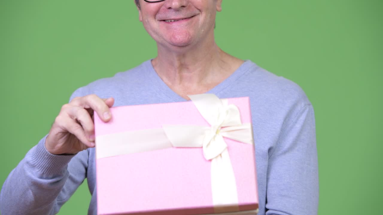 Senior handsome man holding gift box