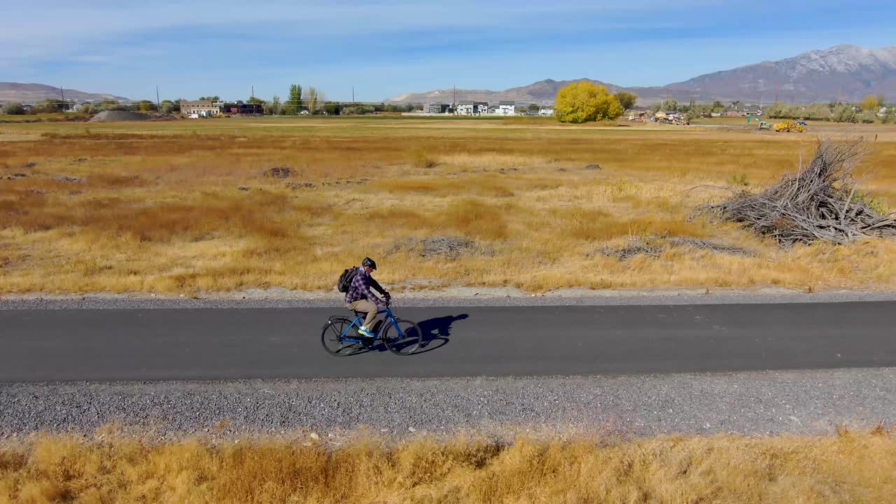 가을에 자연 산책로를 따라 자전거를 타는 성숙한 남자의 조감도