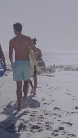 animación de la bandera estadounidense sobre un grupo diverso de amigos caminando con tablas de surf en la playa