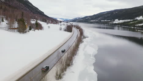 asphalt road by the lakeshore of steinsfjorden in vik, vestland county, norway with snowy landscape in winter