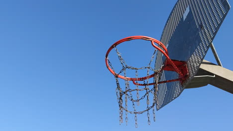 still shot from below basketball hoop on blue sky