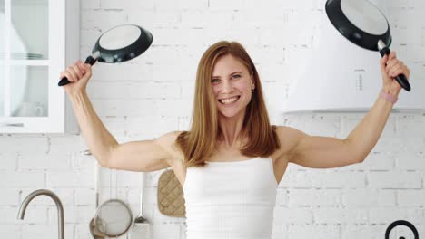 girl with two pans in the kitchen shows different emotions