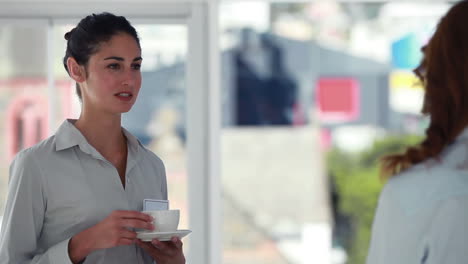 mujeres hablando mientras beben café