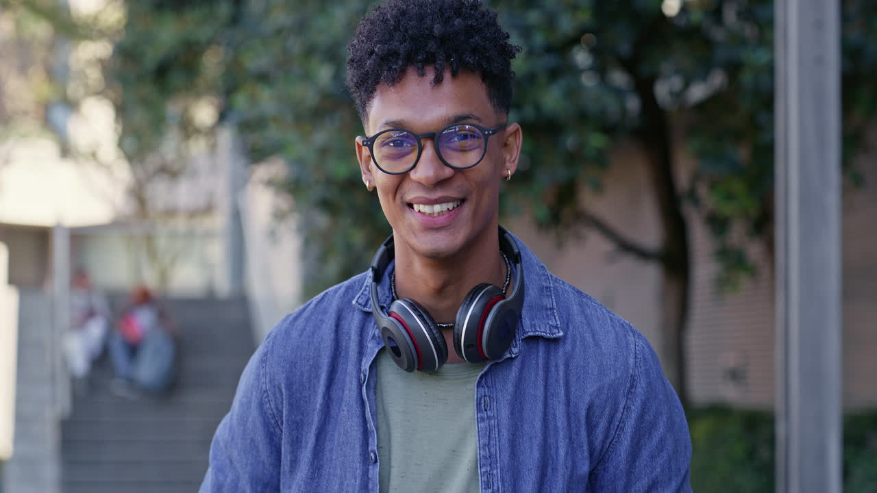 Young man with headphones and laptop on campus