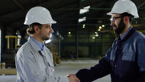 caucasian worker wearing a helmet approaching a coworker