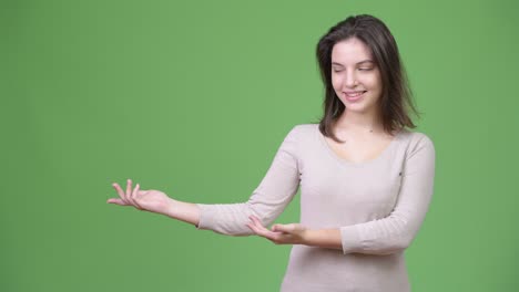 young happy beautiful woman showing something