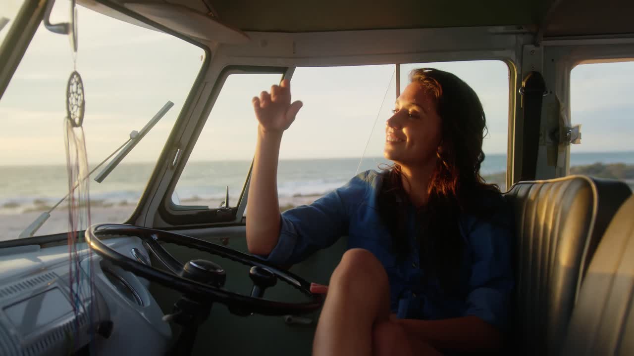 해변 4k에서 캠퍼 밴에서 휴식을 취하는 여성