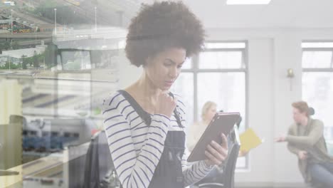 Animation-of-biracial-businesswoman-in-office-over-cityscape