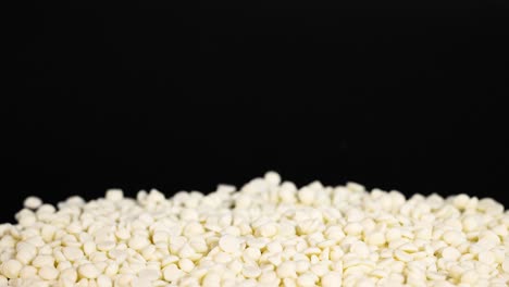 white chocolate chips cascading onto a surface