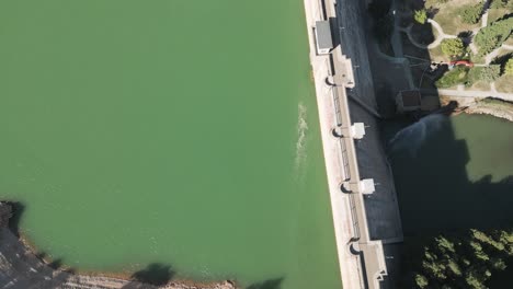 aerial view of a dam in a reservoir of greenish water