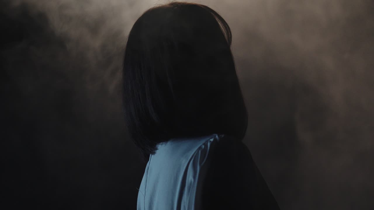 Mysterious woman in the dark with fog. she is dancing in slow motion with fpv mode gimbal