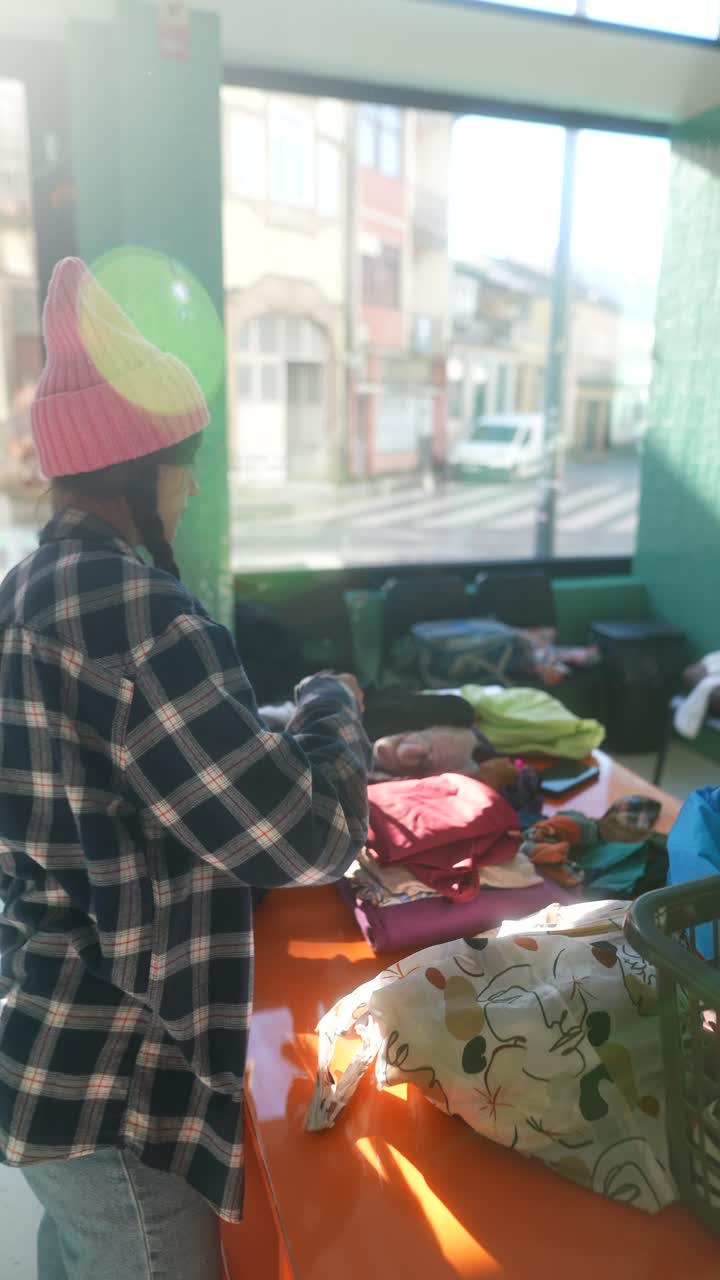 mujer clasificando ropa en el centro de donación