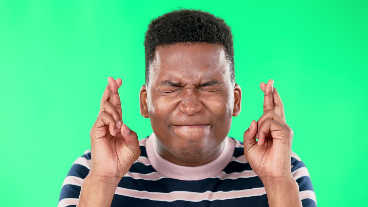 suerte, pantalla verde y dedos del hombre negro cruzados