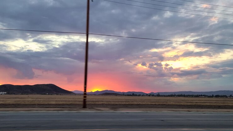 Vista dal finestrino dell'auto di un'area pianeggiante colpita da un incendio boschivo in California al tramonto