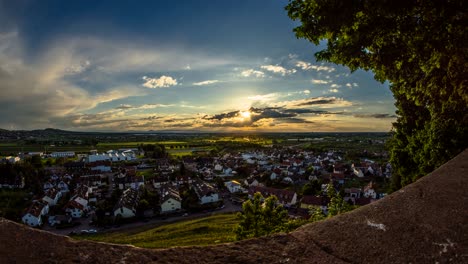 time lapse cloudy sunset over village from above