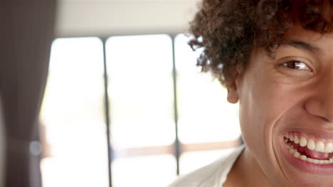 smiling man with curly hair enjoying time at home, close-up portrait, copy space