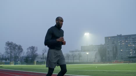 man running on a track at twilight