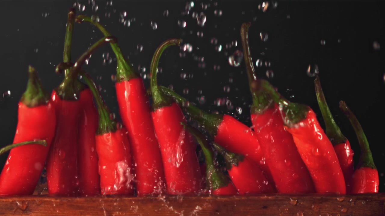 Water Droplets Splashing on Fresh Red Chili Peppers