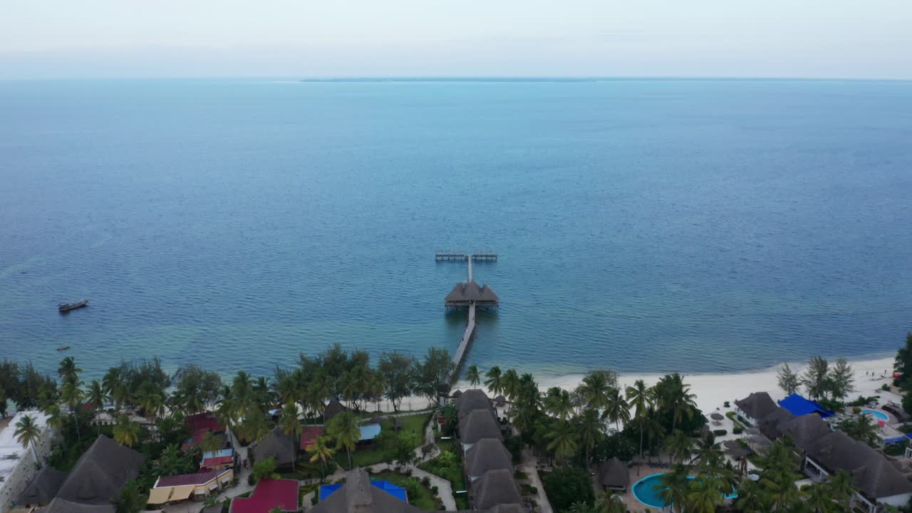 Aerial drone shot tilting down to a pier of an hotel. Zanzibar, Tanzania.