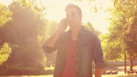 Handsome-man-using-his-smartphone-in-the-park