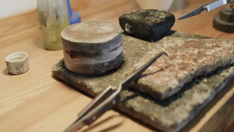 close up of handcraft tools and materials lying on table in workshop in slow motion