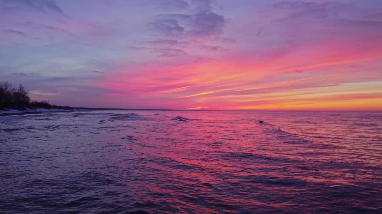 colorido reflejo de la puesta de sol ardiente en la superficie del agua en el mar, panorámica a la derecha