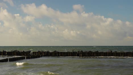 groin on a sunny summer day partly cloudy waves sea