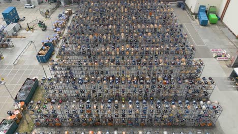 drone top-down view of a dense industrial yard filled with stacked cable reels and electrical components