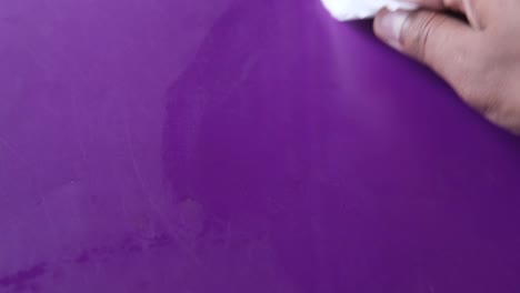 cleaning a purple surface with a tissue