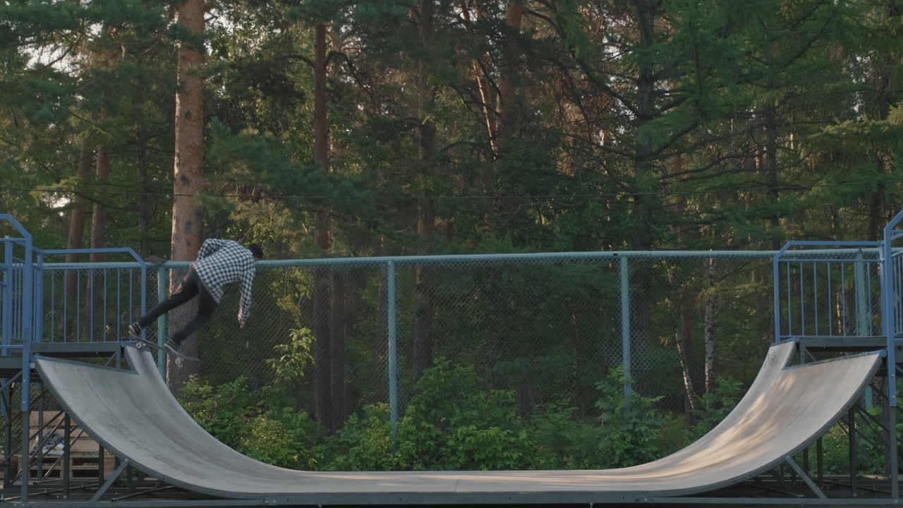 Young Man Skating on Half-Pipe Ramp