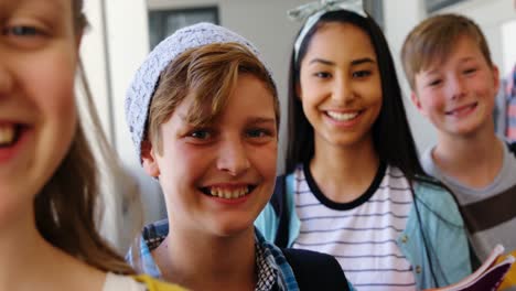 Estudiantes-Sonrientes-De-Pie-Con-Un-Cuaderno-En-El-Pasillo