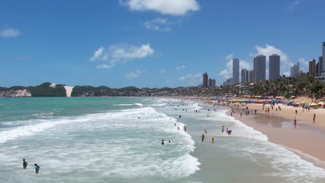 Orilla-De-La-Playa-Llena-De-Gente,-Gente-De-Vista-Aérea-En-Las-Olas-De-La-Costa,-Ponta-Preta,-Natal