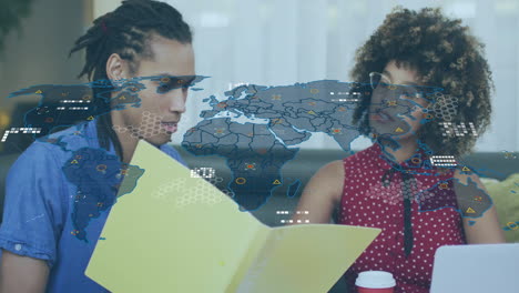 Two people discussing documents with world map and data overlay animation