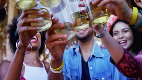 Group-of-friends-toasting-beer-glasses-at-music-festival-4k