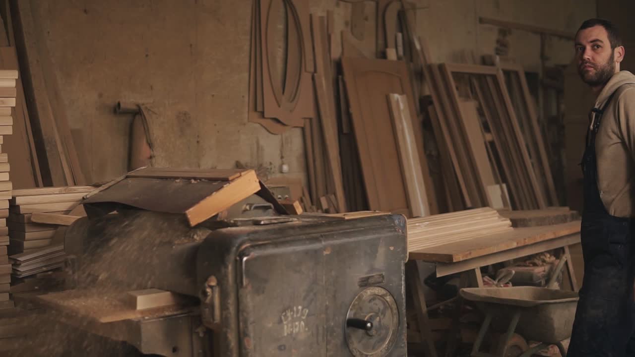 el proceso de trabajo de una gran máquina de molienda. el maestro muele la barra de madera. taller de carpintería
