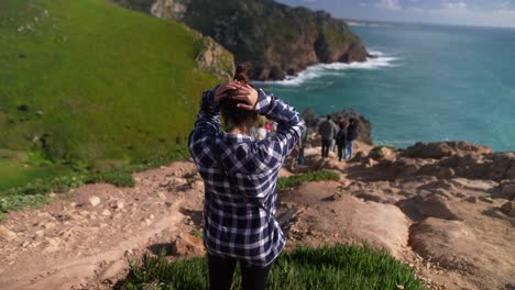 una mujer disfrutando de la vista desde cabo da roca (portugal)