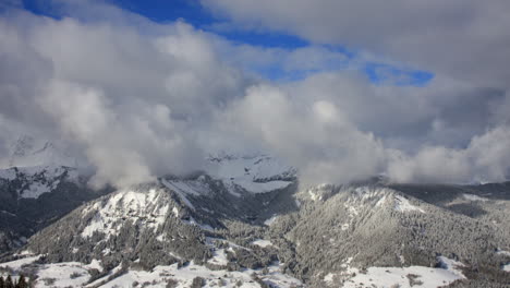 time-lapse of winter mountain scenery , with rolling clouds and alpine peaks in the french alps near the resort of praz sur arly