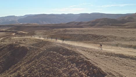 imágenes aéreas de un grupo de ciclistas que recorren senderos para bicicletas en el desierto