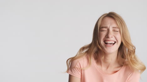 caucasian woman showing stop gesture while laughing on camera.