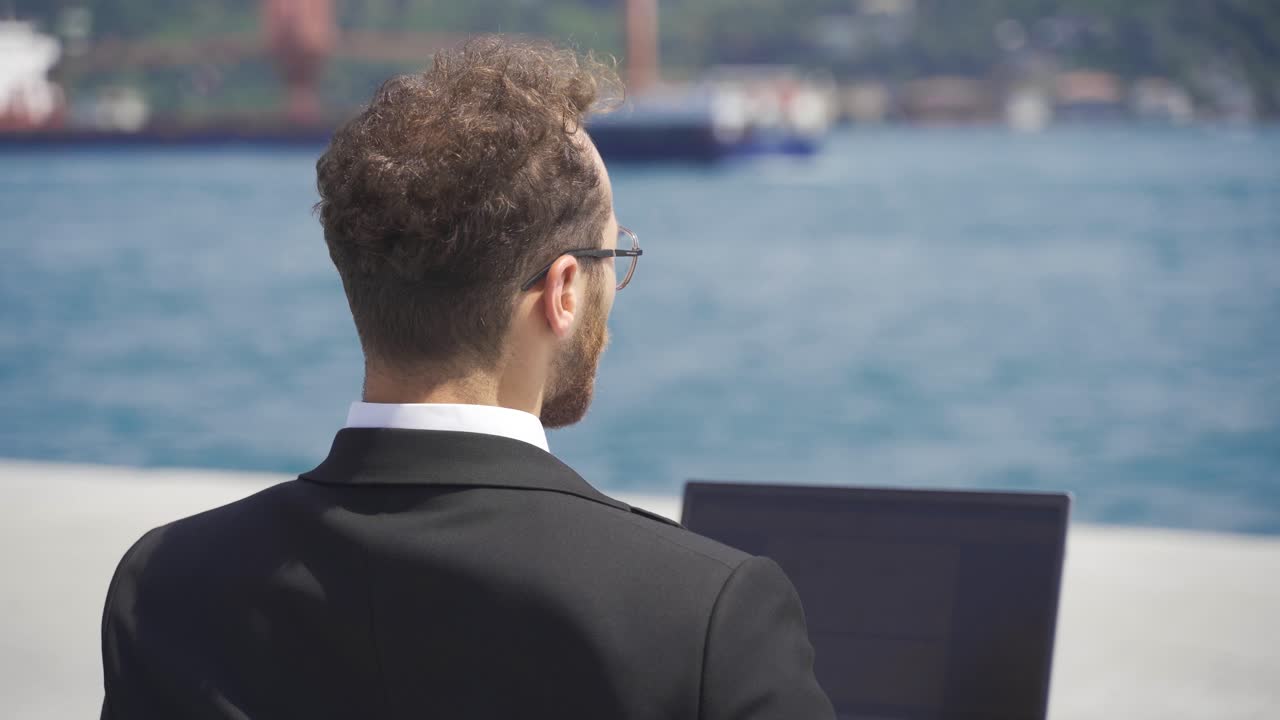 Uomo d'affari in giacca e cravatta che lavora al computer portatile