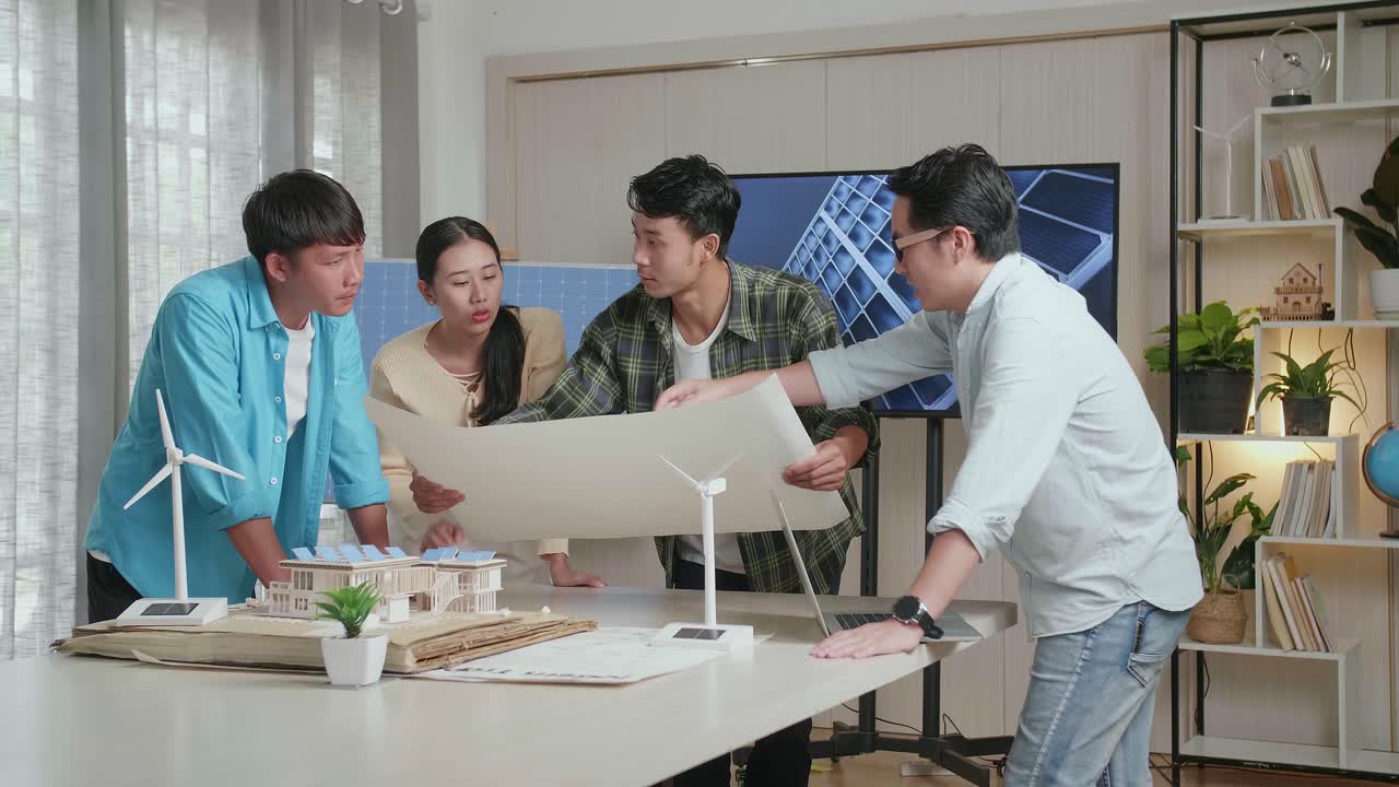 아시아 엔지니어 그룹은 태양 전지 패널 집 모델과 함께 사무실에서 손에 든 블루프린트 작업에 대해 논의합니다.